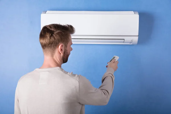 Rear View Young Man Operating Air Conditioner Mounted Blue Wall — Stock Photo, Image