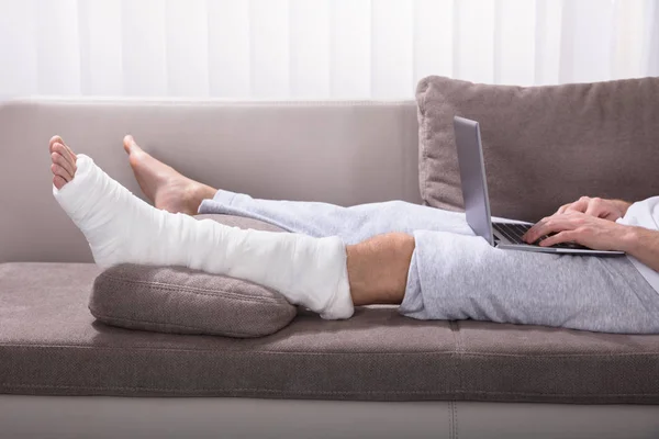 Man Broken Leg Sitting Sofa Using Laptop — Stock Photo, Image