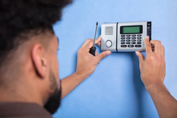 Nahaufnahme Eines Mannes Der Ein Sicherheitssystem Einer Blauen Wand Installiert — Stockfoto