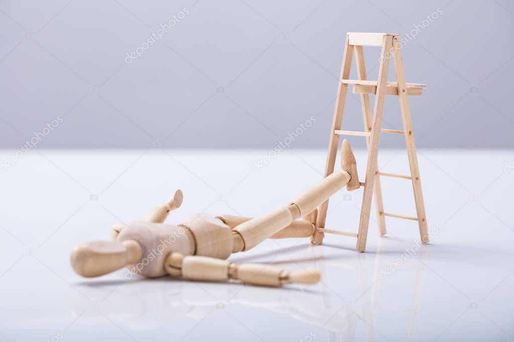 Wooden Figure Lying On Floor After Falling From Ladder