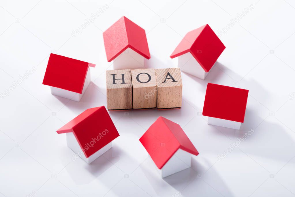 Homeowner Association Wooden Blocks Surrounded With Miniature House Models Over The White Background