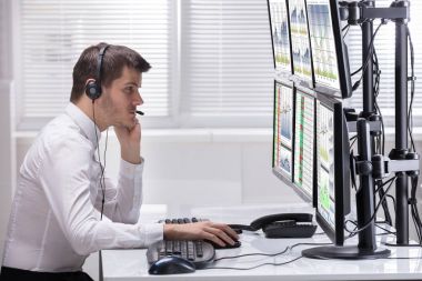 Grafikler birden çok bilgisayar ekranlarında analiz bir genç erkek borsa Broker yan görünüm