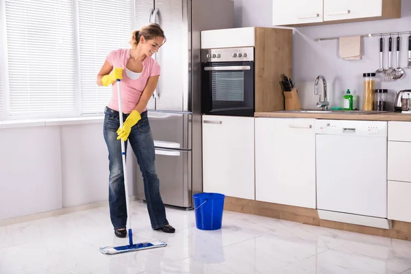 Sonriente Mujer Joven Limpieza Piso Cocina Con Fregona Cocina Casa —  Fotos de Stock