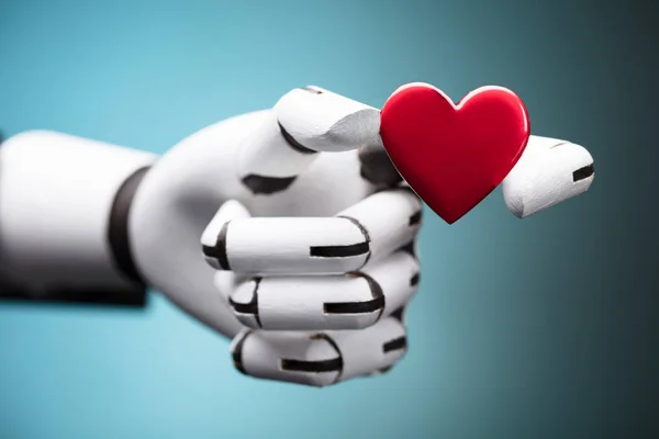 Close-up Of A Robot\'s Hand Holding Red Heart