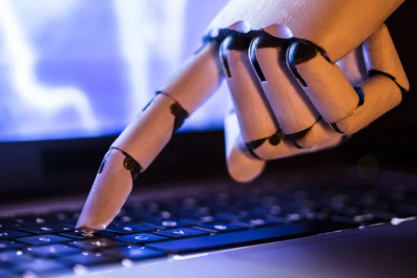 Close-up Of A Robot\'s Hand Typing On Laptop