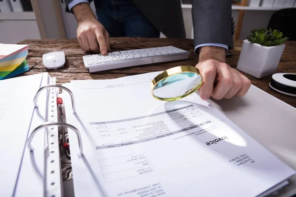 Close Businessperson Hand Analyzing Bill Magnifying Glass Wooden Desk — Stok Foto