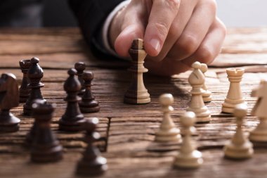 Kral satranç parça ahşap masanın üzerinde tutan işadamı'nın el