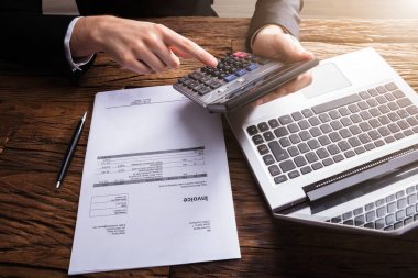 İşadamı'nın el Bill hesap makinesi ile ahşap Resepsiyon üzerinde hesaplama