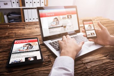 Dizüstü bilgisayarda Online haber okurken Smartphone kullanarak bir işadamının Close-Up