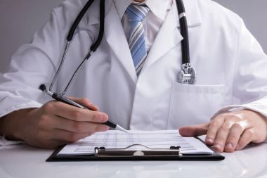 Doktor el beyaz masa üzerinde rapor analiz Close-Up