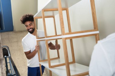 Boş taşıyan iki erkek Movers merdiven evde rafta beyaz