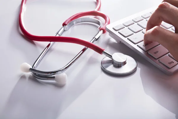 Arzthandtippen Auf Tastatur Neben Stethoskop Auf Weißem Schreibtisch — Stockfoto