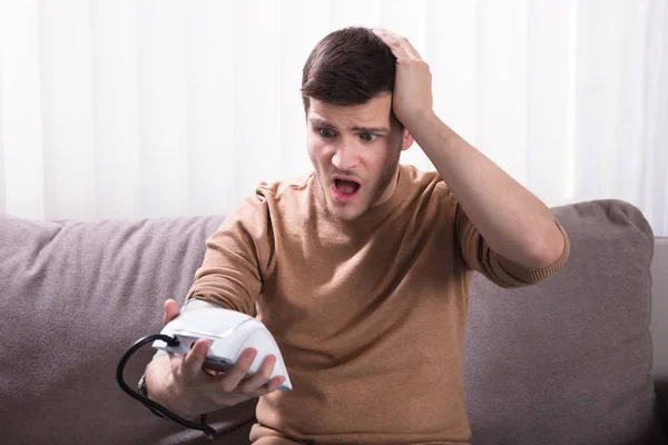 Joven Sorprendido Midiendo Presión Arterial Casa —  Fotos de Stock