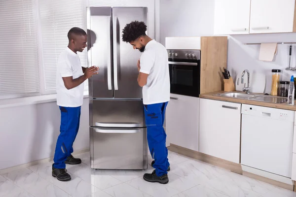 Dos Hombres Mueven Uniforme Fijación Del Congelador Cocina Casa — Foto de Stock