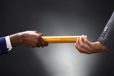Golden Baton ortağı için gri arka plan üzerinde geçen adam