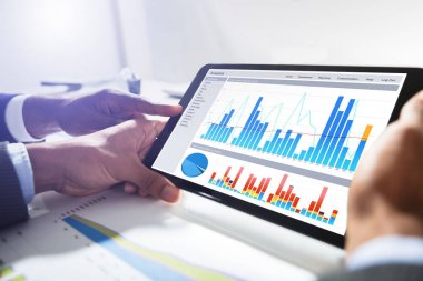 İki iş adamları ile birlikte finansal grafik dijital Tablet üzerinde çalışan Close-Up