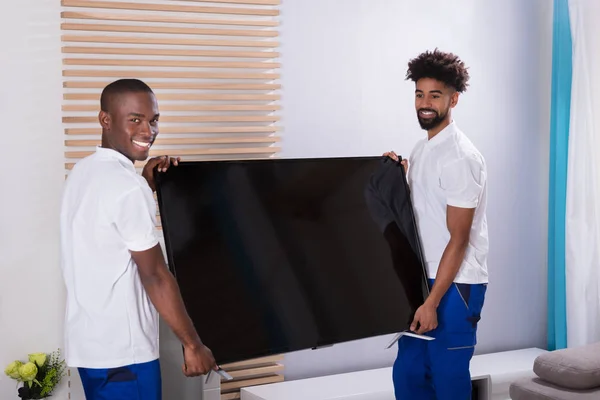 Portrait Deux Jeunes Hommes Souriants Plaçant Télévision Dans Salon — Photo