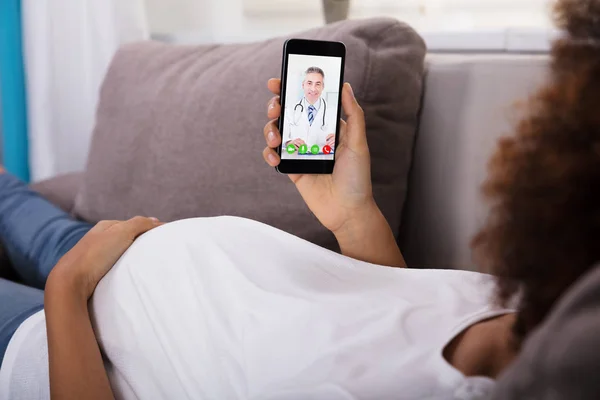 Schwangere Liegt Auf Sofa Videokonferenz Mit Arzt Auf Smartphone — Stockfoto