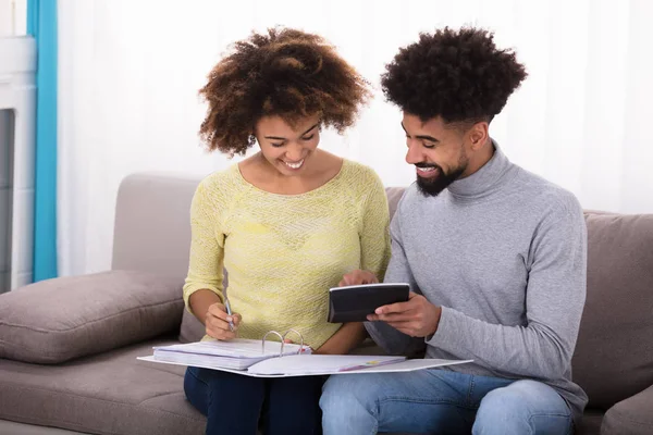 Junges Paar Sitzt Auf Sofa Und Berechnet Rechnung Mit Taschenrechner — Stockfoto