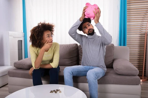 Frau Sitzt Auf Sofa Und Blickt Auf Sparschwein Das Von — Stockfoto