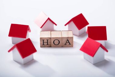 Homeowner Association Wooden Blocks Surrounded With Miniature House Models Over The White Background