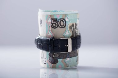 Rolled Up Russian Rubles Tied With Belt Against White Background clipart