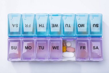 Pink Plastic Pill Organizer Shot And Medical Pills On White Background clipart