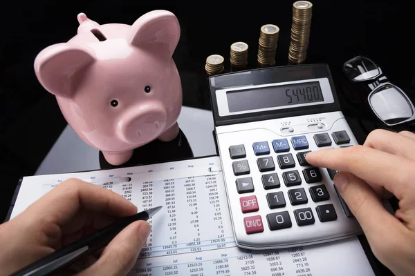 Businessperson Hand Calculating Financial Data Piggy Bank Stacked Coins Desk — Stock Photo, Image