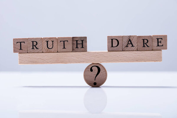 Truth And Dare Arranged Blocks Are Balanced On The Wooden Seesaw With Question Mark