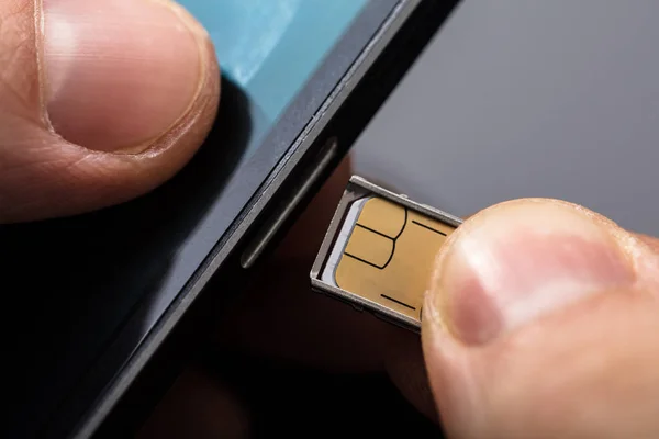 携帯電話の背面に Sim カードを挿入する人のクローズ アップ — ストック写真