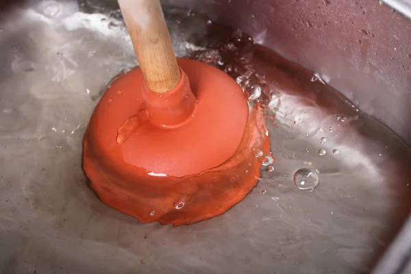 水で満たされた洗面器でオレンジ カップ プランジャー — ストック写真