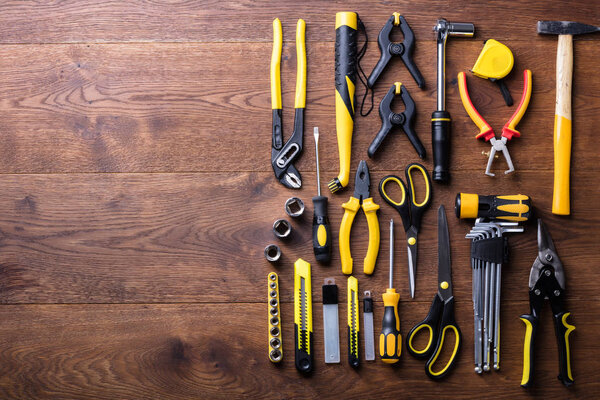 Overhead View Of Many Yellow Repair Tools Arranged On Wooden Table