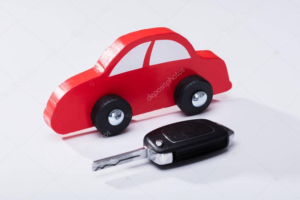 Close-up Of Red Car And Key On White Background