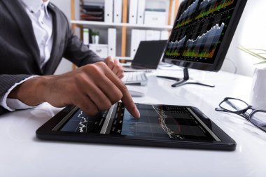 İşyerinde dijital tablet grafik ile çalışan bir işadamının'ın el Close-Up