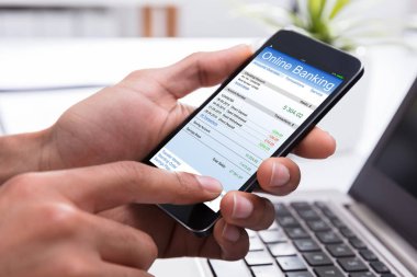Bir işadamının'ın el smartphone cep telefonu ile işyerinde Online Bankacılık yapıyor Close-Up