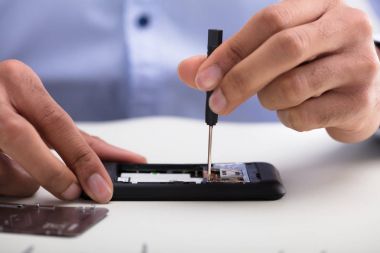 Bir teknisyen el masa üzerinde cep telefonu tamir Close-Up