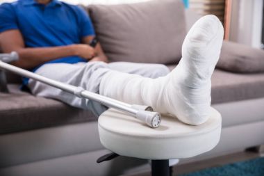 Close-up Of A Man's Broken Leg And Crutches clipart