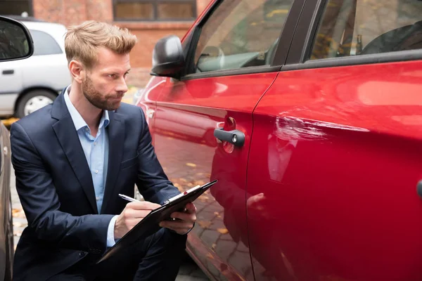 Försäkringsagent Skriva Urklipp Samtidigt Undersöka Bilen Efter Olycka — Stockfoto