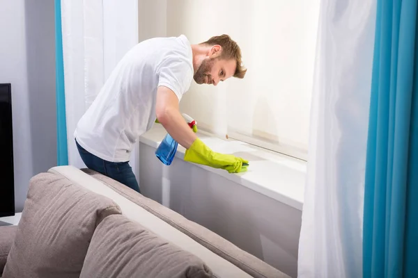 Joven Conserje Masculino Limpiando Alféizar Ventana Con Esponja Sala Estar — Foto de Stock