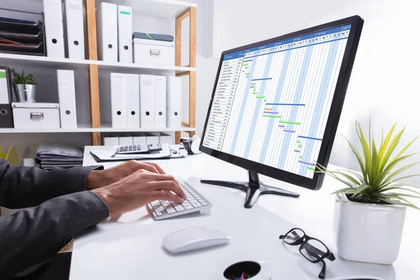 オフィスのコンピューターを使用してガント チャートで作業する実業家の手のクローズ アップ — ストック写真