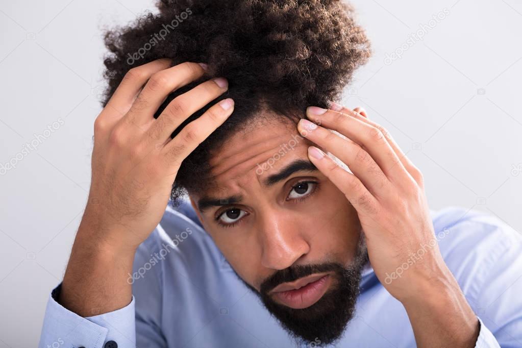 Close-up Of A Young Man Examining His Hair