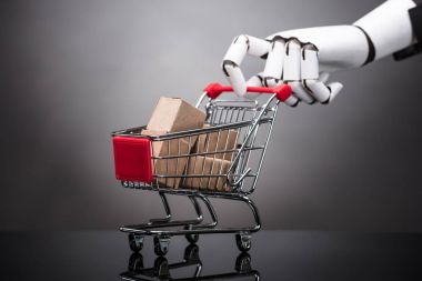 Alışveriş sepeti gri arka plan üzerine karton kutular ile tutarak robot