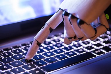 Bir robotun el dizüstü bilgisayarda yazarak, yakın çekim