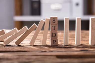 Close-Up düşen Dominos Stop metin masanın üzerinde gösterilen ahşap bloklar tarafından durduruldu