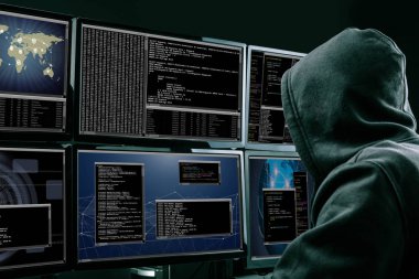 Arkadan görünüş bir hacker Office veri çalmak için birden fazla bilgisayar kullanma