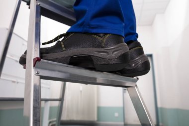 Close-up Of Man Standing On Steel Ladder clipart