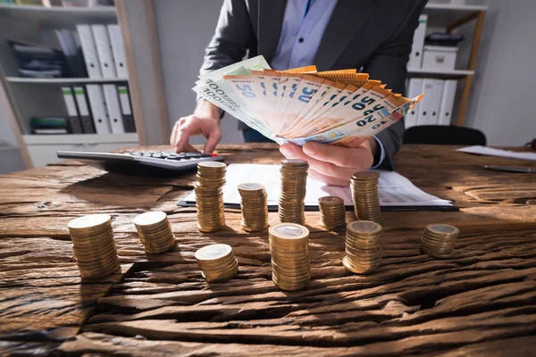 Empresário Calculando Notas Euro Com Moedas Ouro Empilhadas Mesa — Fotografia de Stock