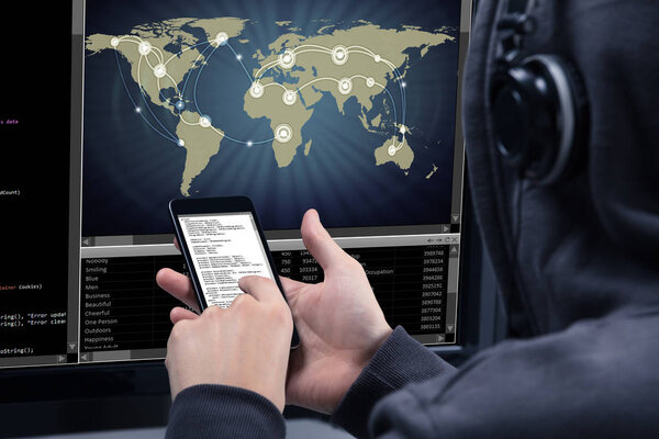 Хакер с помощью мобильного телефона для кражи данных с экрана компьютера отображает карту мира
