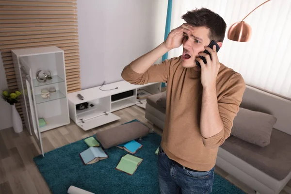 Worried Young Man Talking Phone Stolen Television Set Home — Stock Photo, Image