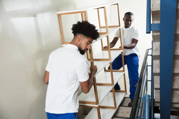 Dois Homens Que Transportam Prateleira Branca Vazia Escada Casa — Fotografia de Stock